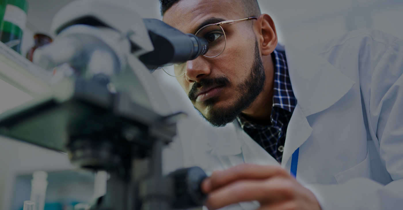 man looking through microscope